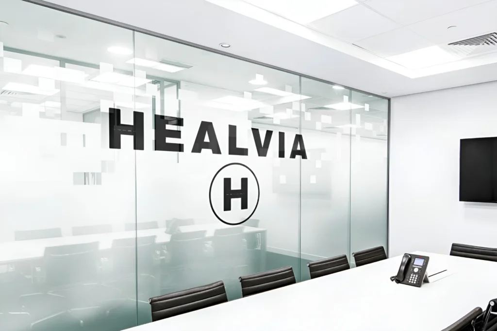HEALVIA company office with meeting table and HEALVIA logo on the wall