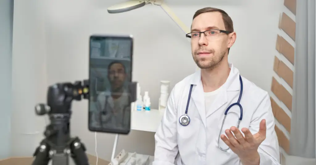 a doctor setting in front of phone camera filming himself for social media