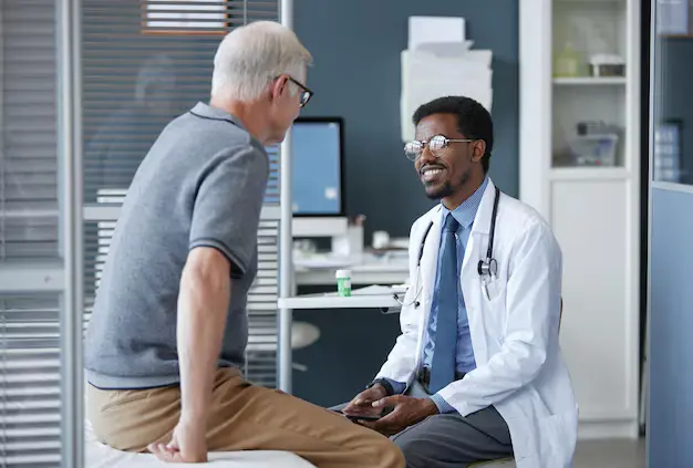 Doctor consulting and talking with a patient in a hospital setting, demonstrating patient care and communication in a clinical environment.